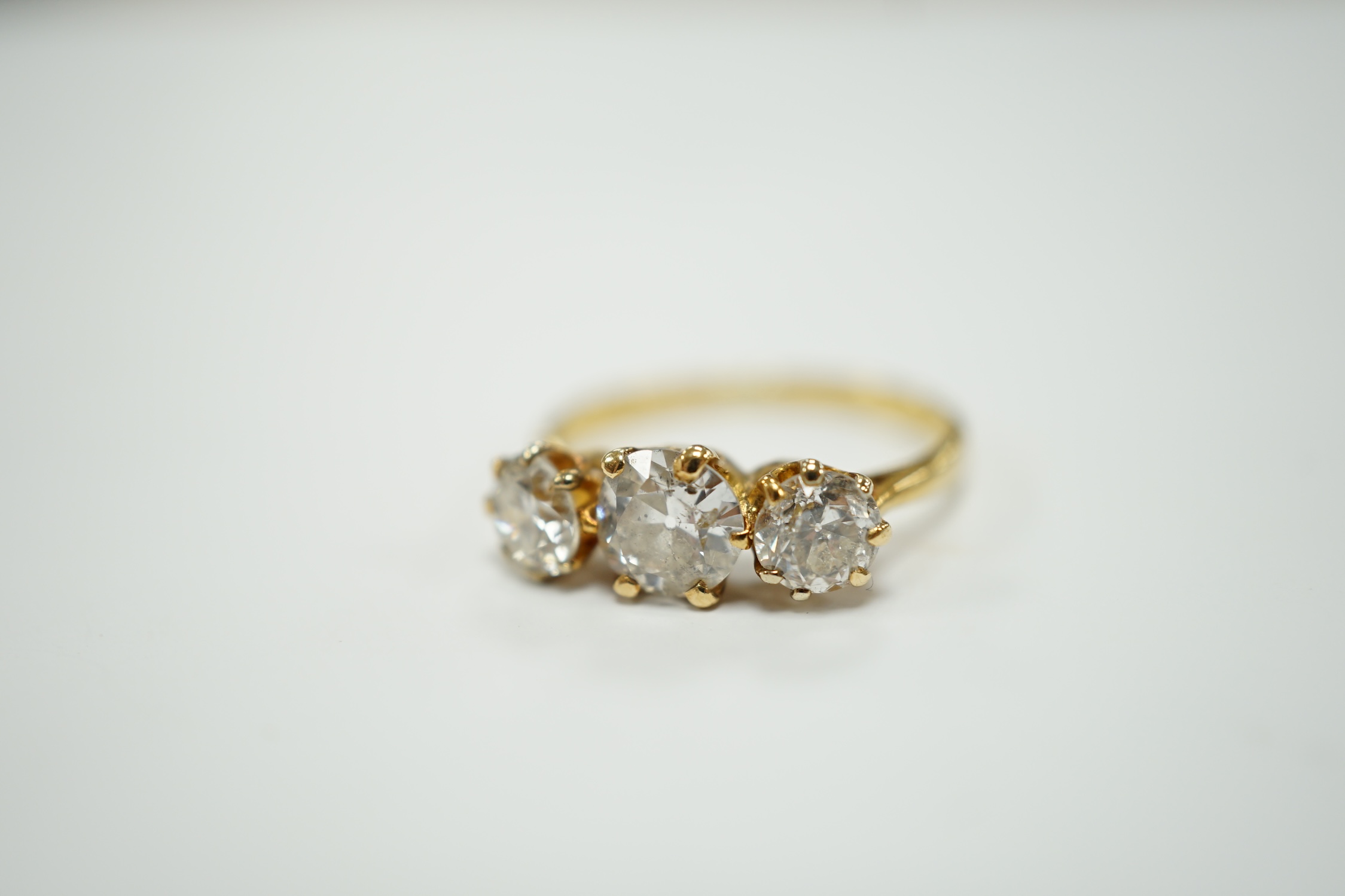 A George V 18ct gold and three stone diamond set ring, the central stone weighing approx. 0.60ct, size L, gross weight 2.5 grams.
